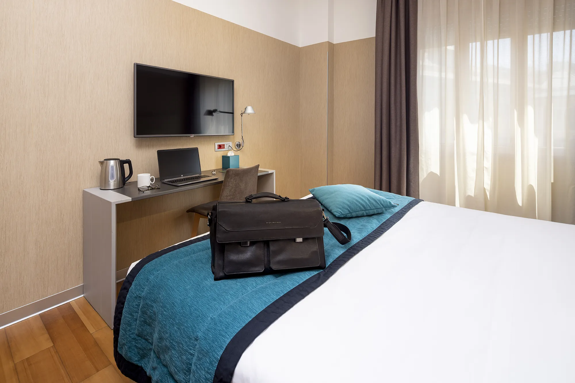 Pictured is a double room for business travellers in Genoa. In front of the bed a desk where you can work on your PC